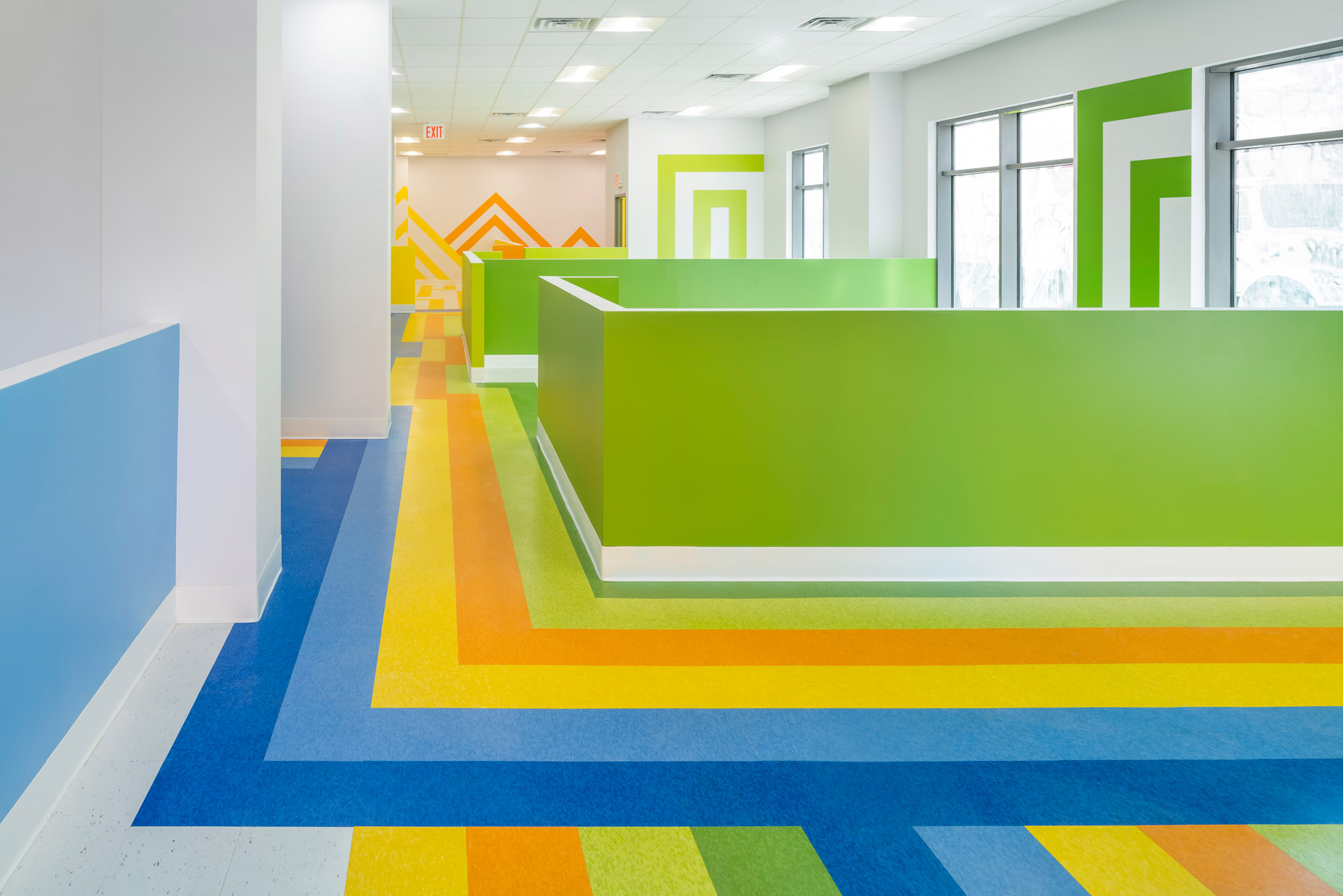 Brightly coloured corridor with geometric shapes within daycare of social housing project