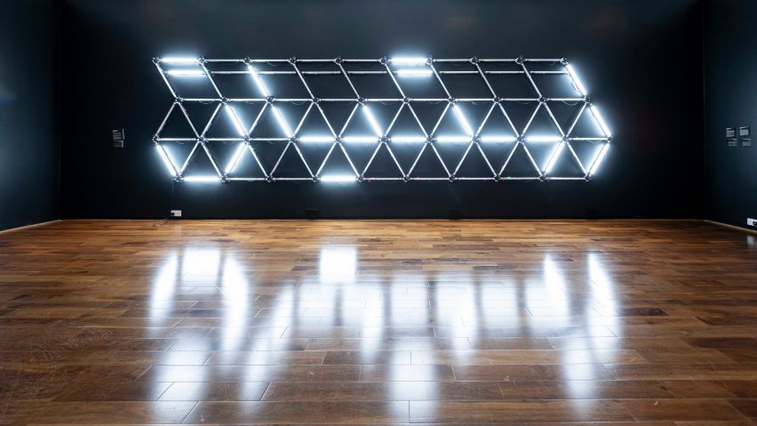Lighting system mounted onto wall with reflection in polished wood floor