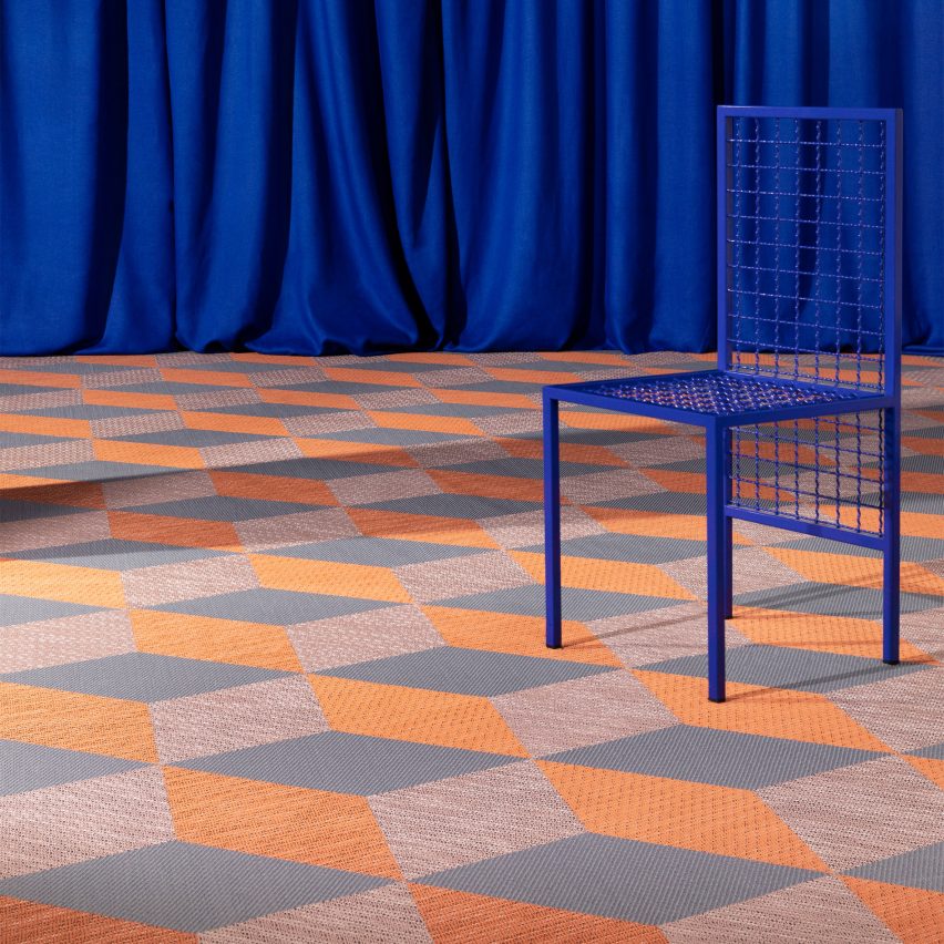 Orange and grey carpet tiles with a blue chair and curtains