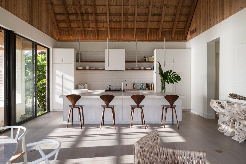 White kitchen under gabled roof with timber bar stools
