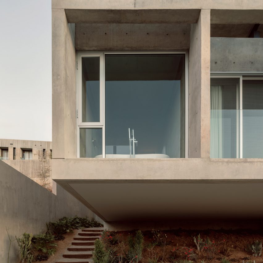 Cantilevering concrete box-like structure attached to house