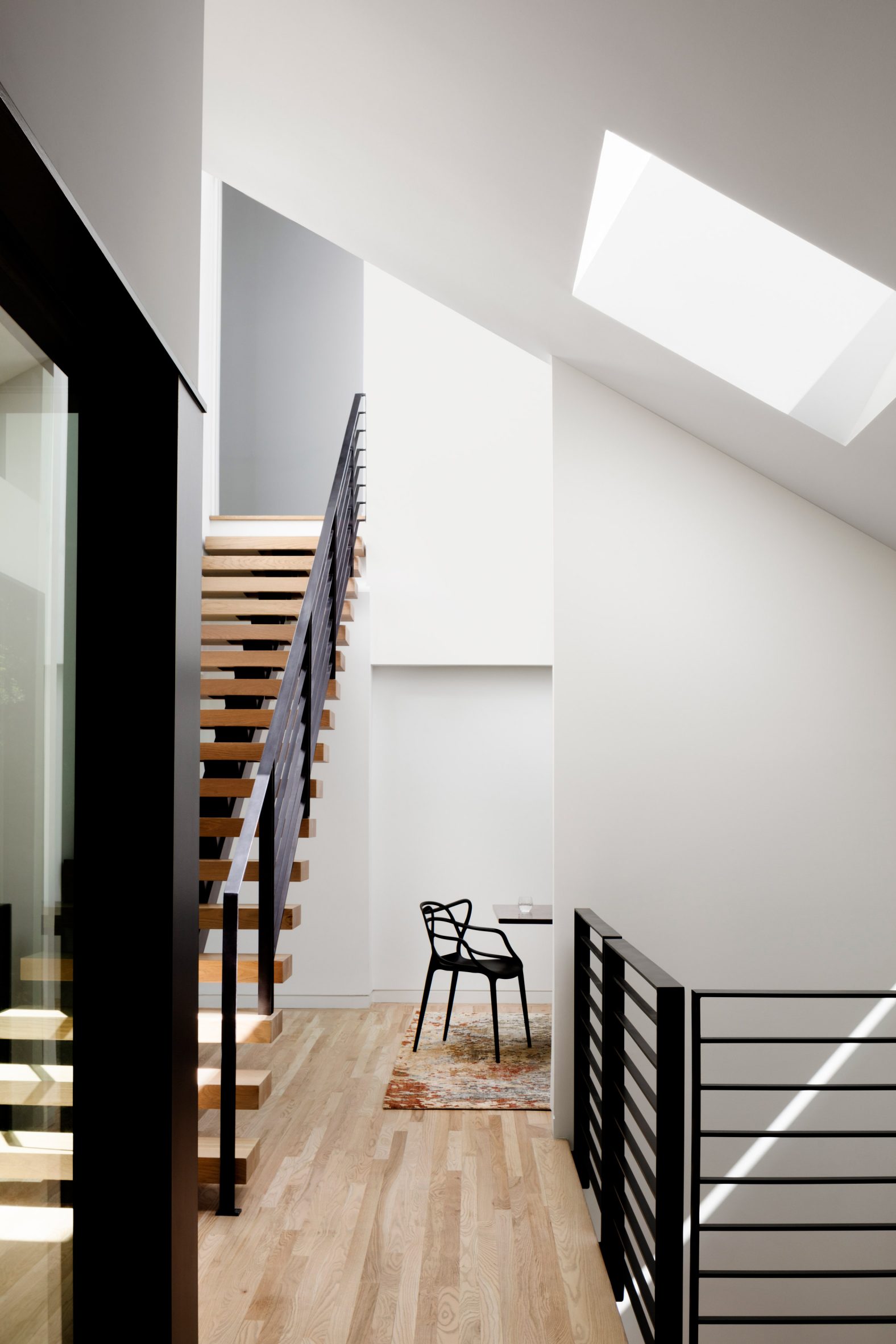 sculptural roof skylight with black steel rail on floating staircase