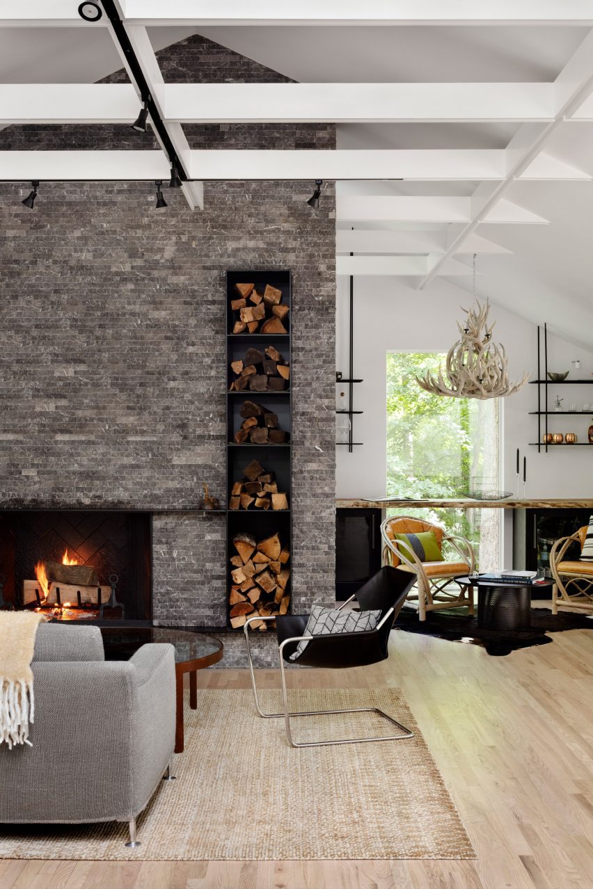 Stone fireplace with modern chairs and an antler chandelier