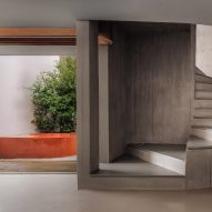 A concrete room with a curving concrete staircase