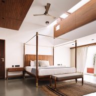 Bedroom with polished concrete floors, white walls and a wooden four-poster bed
