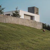 Exterior of a home on a grass mound with board-formed concrete walls