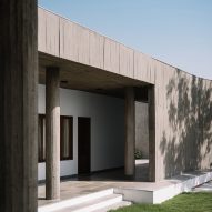 Exterior of a home on a grass mound with board-formed concrete walls