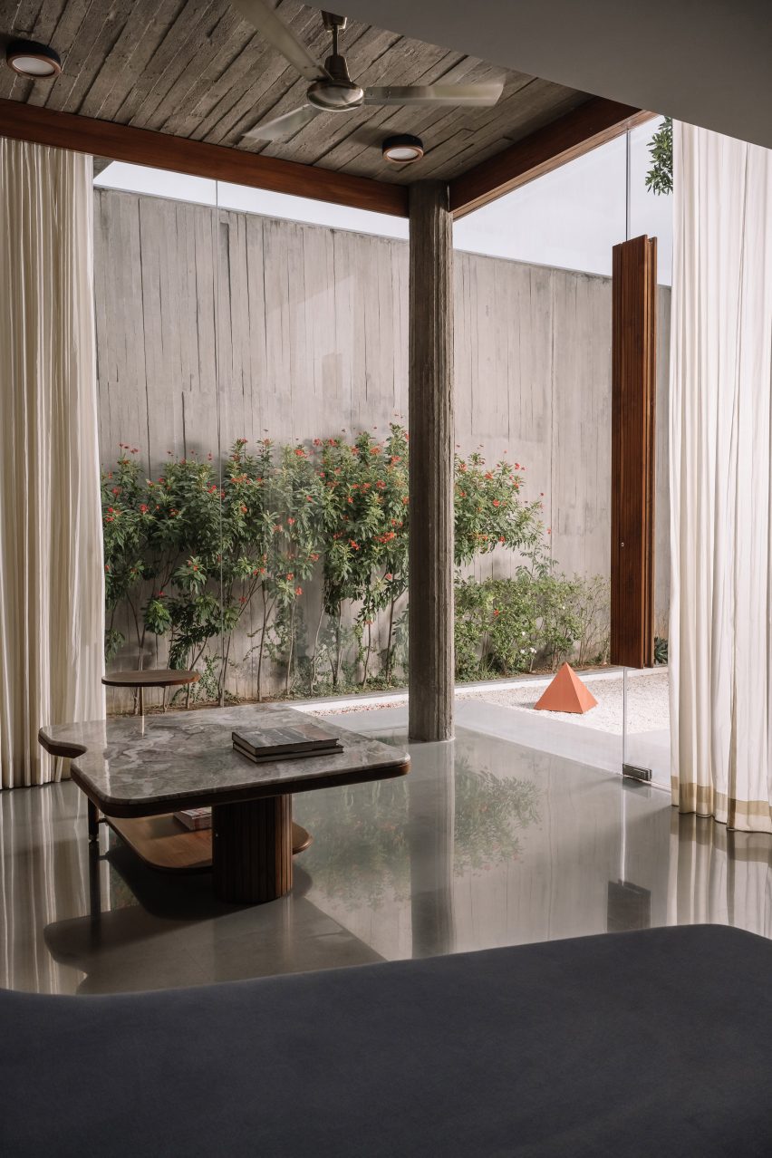 A concrete room with large openings and a coffee table