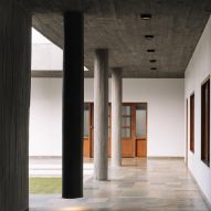 A covered outdoor walkway next to a courtyard with concrete columns