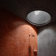 Wet room with red and grey concrete walls and circular skylight