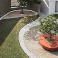 Grass courtyard with curved paving and trees
