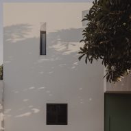 Exterior white wall with two small windows at the El Tiron house by FMT Estudio
