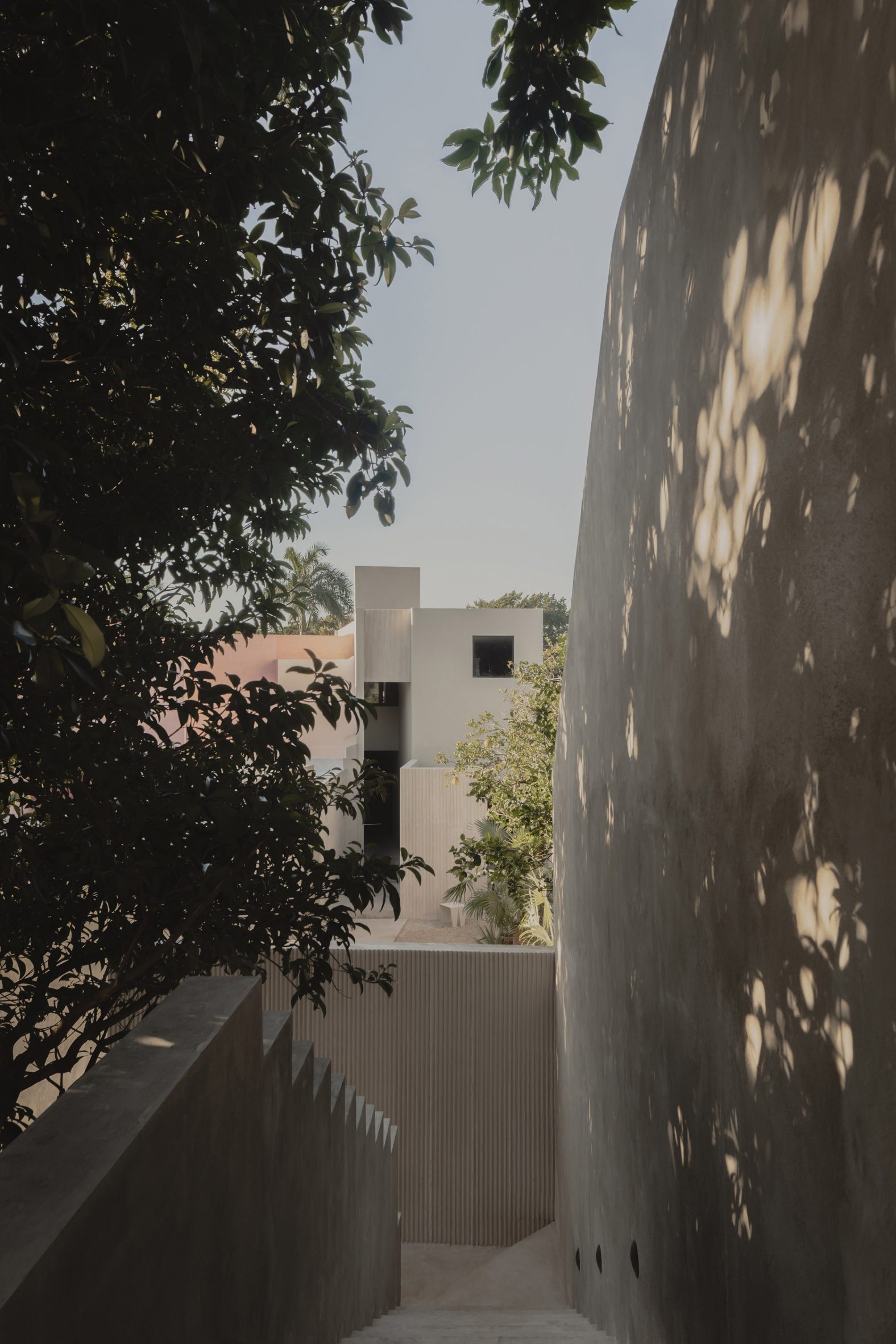 A concrete staircase overlooking a concrete house and trees
