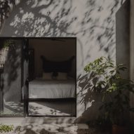 An outdoor patio by a concrete home with slading glass doors leading to a bedroom