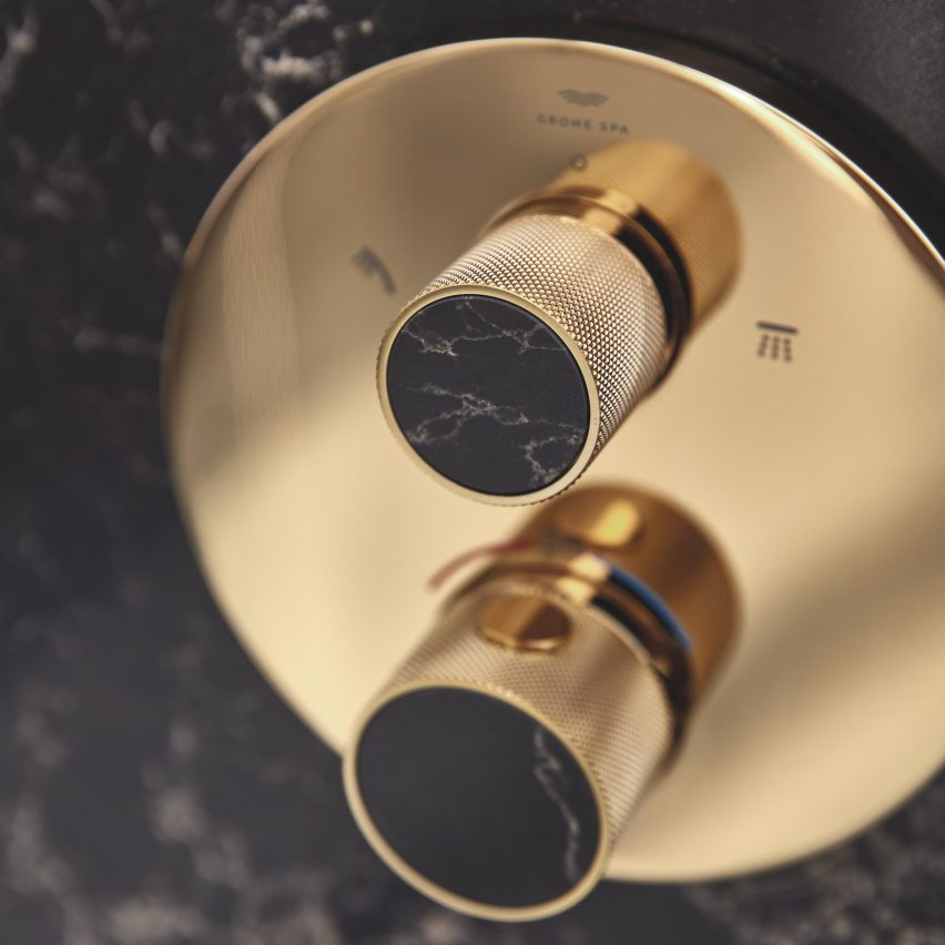 Gold shower mixer on black marble wall