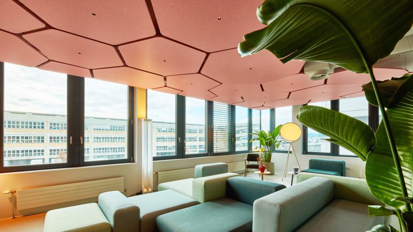 Pink hexagonal ceiling tiles with LED lights in centre in office
