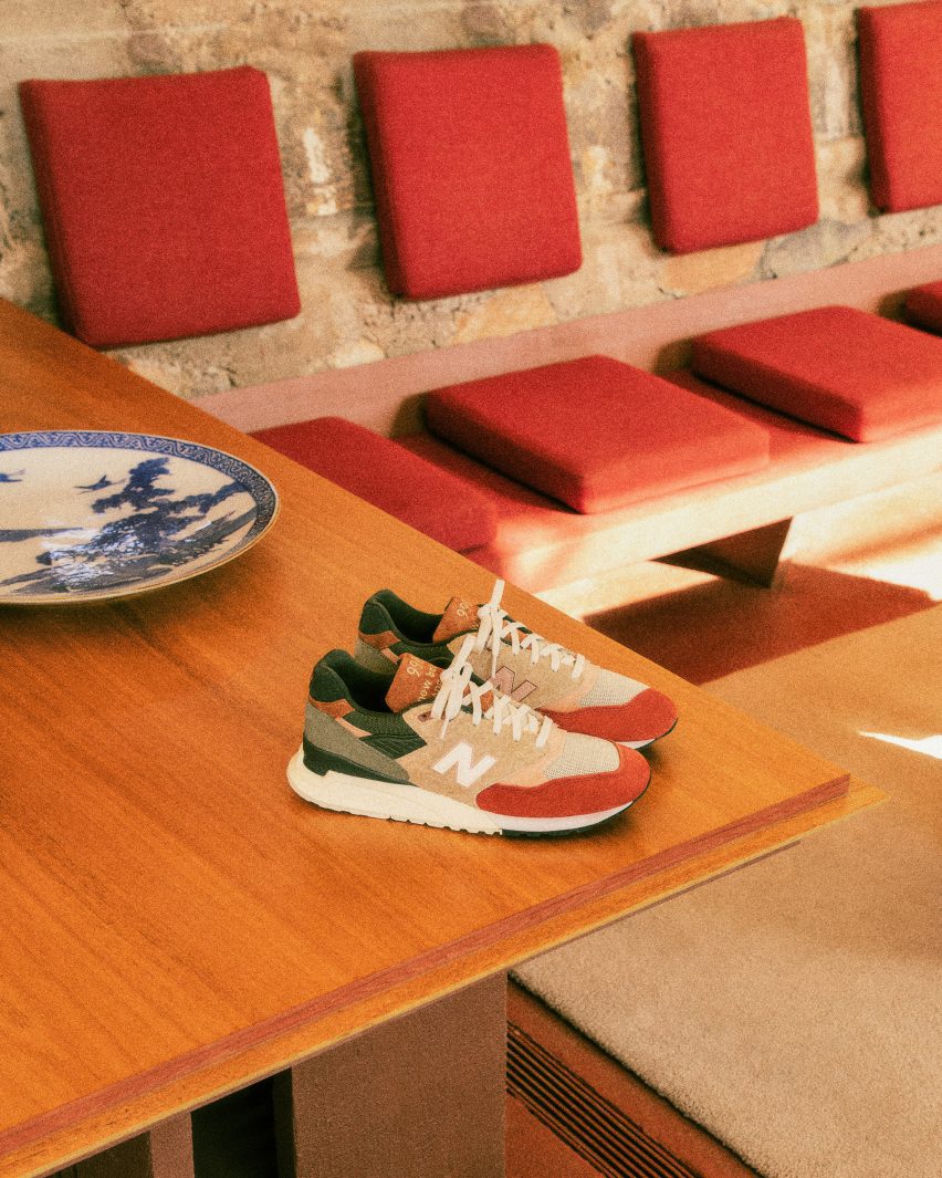 Sneakers on table with red modernist couch behind them and china on the table
