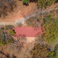 Aerial view of a home with a red roof on a sandy hill in Mexico with trees