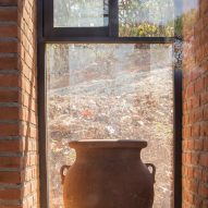 Cermaic pot on a window sill with brick walls