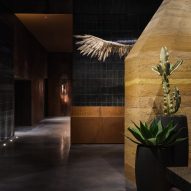 Lobby di un hotel Moxy a Los Angeles con muro di terra battuta e ala di gufo