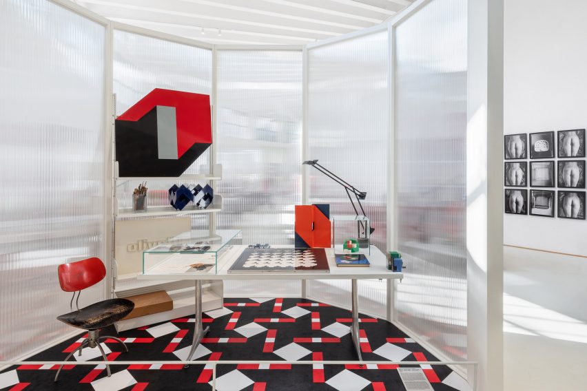 Photo of an interior installation showing a creative office environment in graphic red, black, white and grey at the Museo del Design Italiano
