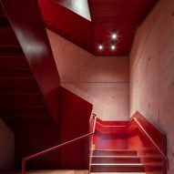 Red interior staircase at the International Rugby Experience building by Niall Nclaughlin Architects