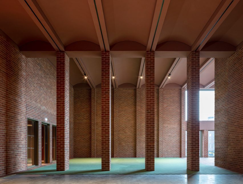 Red-brick double-height interior with slim brick columns at the International Rugby Experience building by Niall McLaughlin Architects