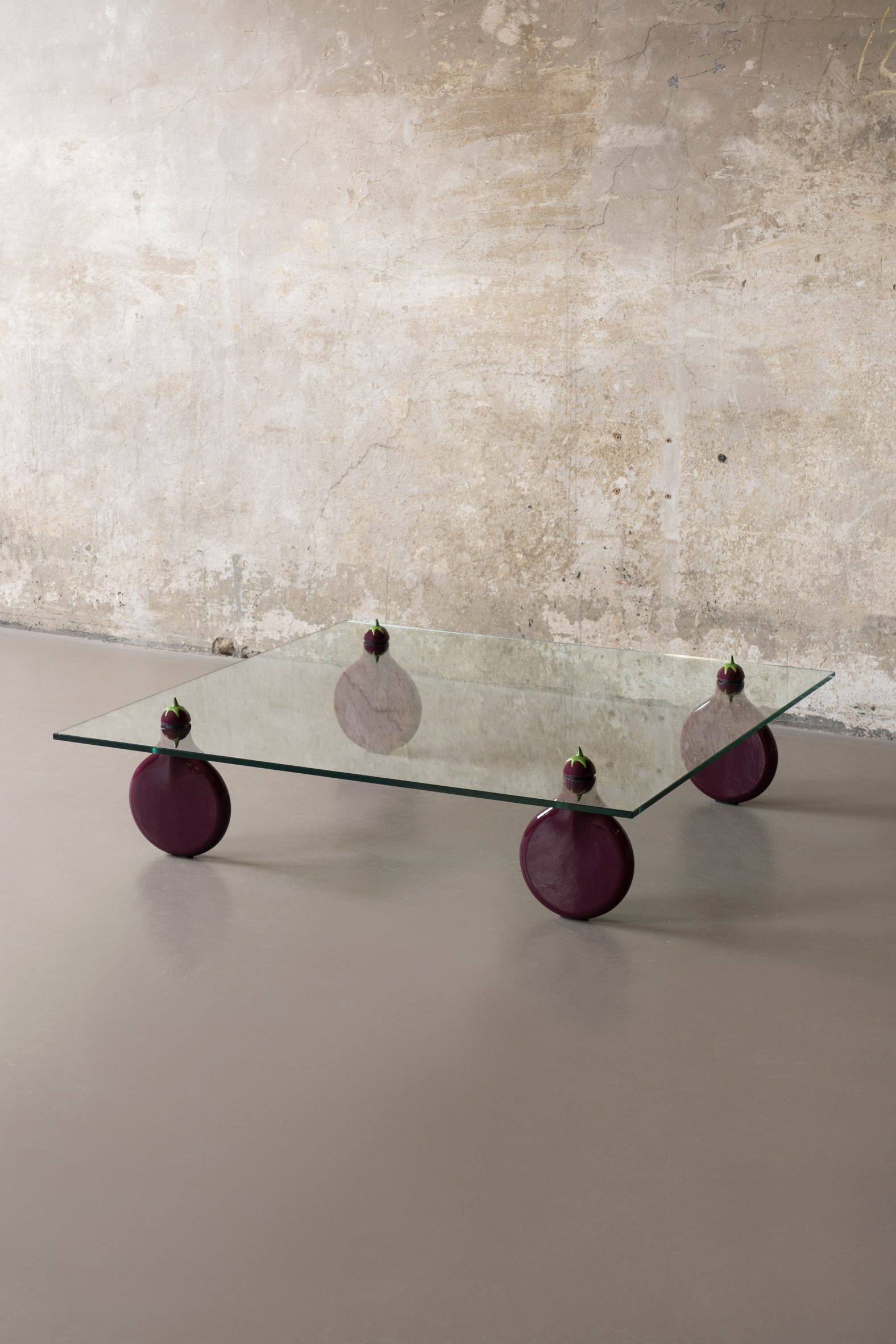 Glass coffee table with aubergine wheel legs by Robert Stadler