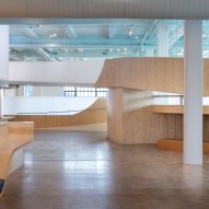 Interior of a museum with wood flooring and curved wooden elevated walkways