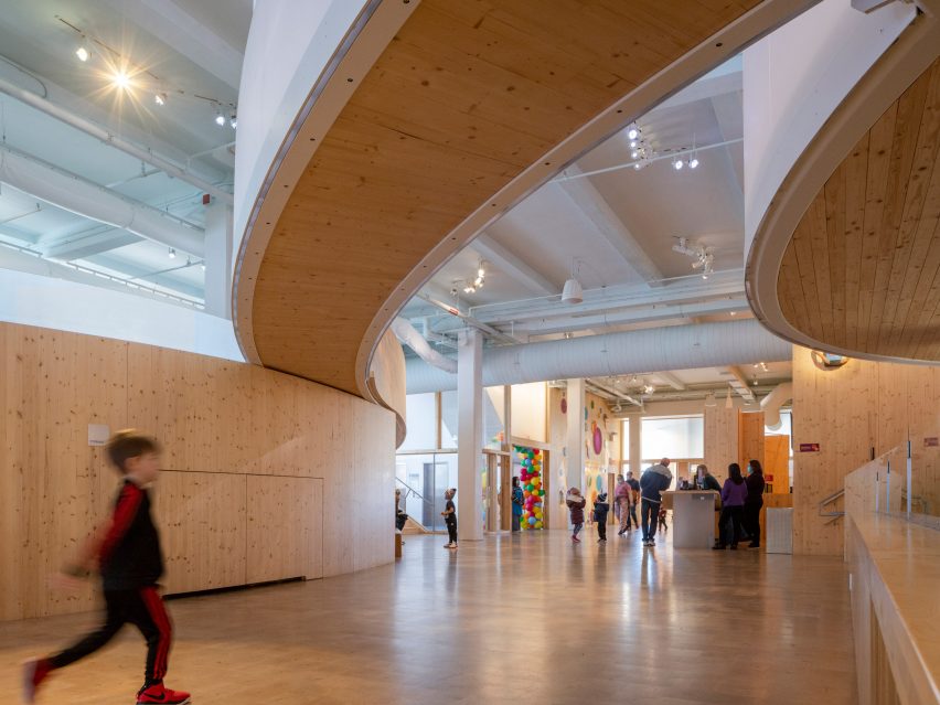 Interior of the Bronx Children's Museum with wood flooring and overhead wooden walkways