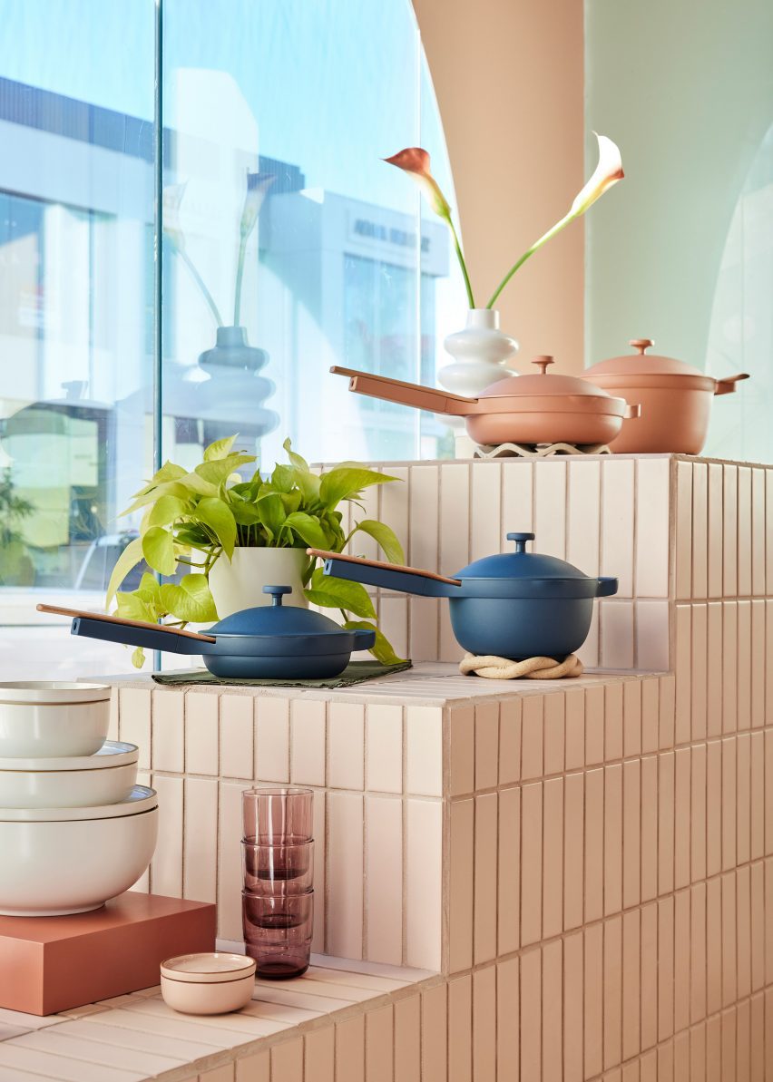 Our Place pots and pans displayed on a tiered stand covered in cream tiles
