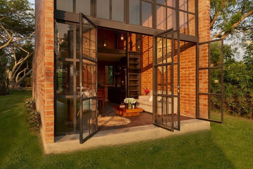 Exterior of a brick micro home with double-height window facade