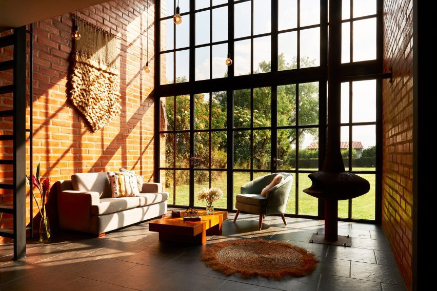 Double-height living space with brick walls and grid window facade