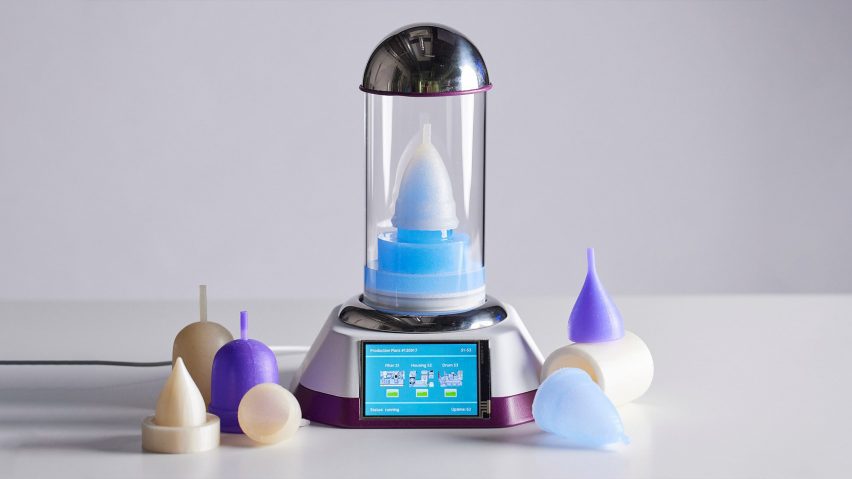 Photo of an device with a menstrual cup placed upside down in a domed glass incubator, with a screen interface in the base