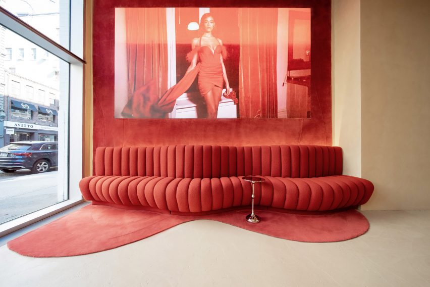 Ribbed red seating and carpet on the wall