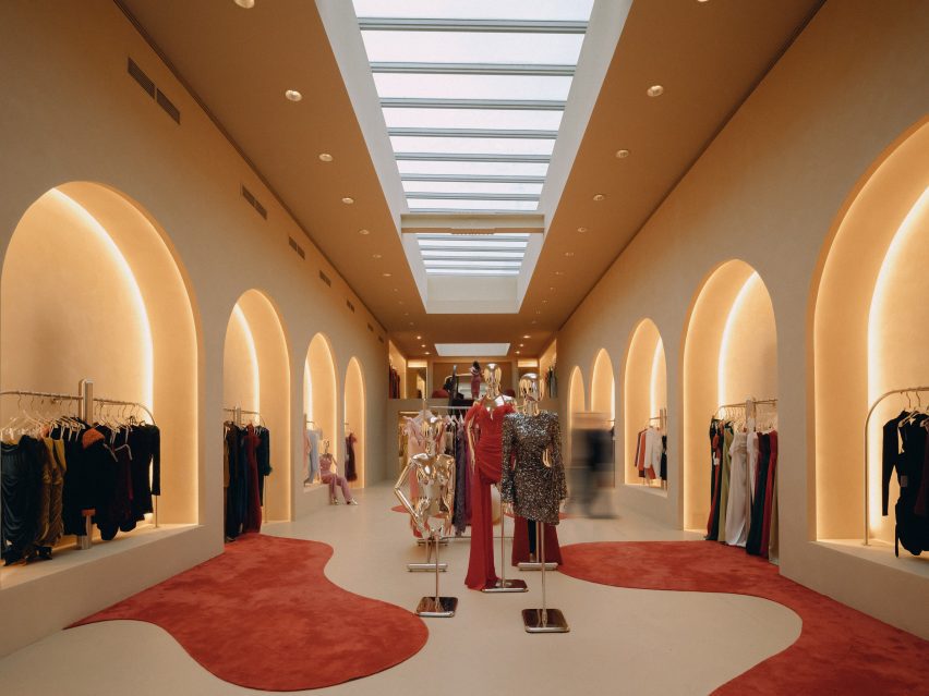 Rows of arched colonnades displaying garments on both sides of the store