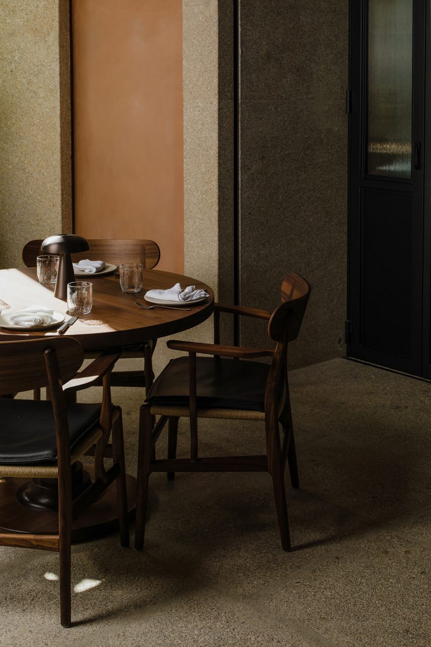 Pared enyesada y mesa de madera dentro del restaurante Porto
