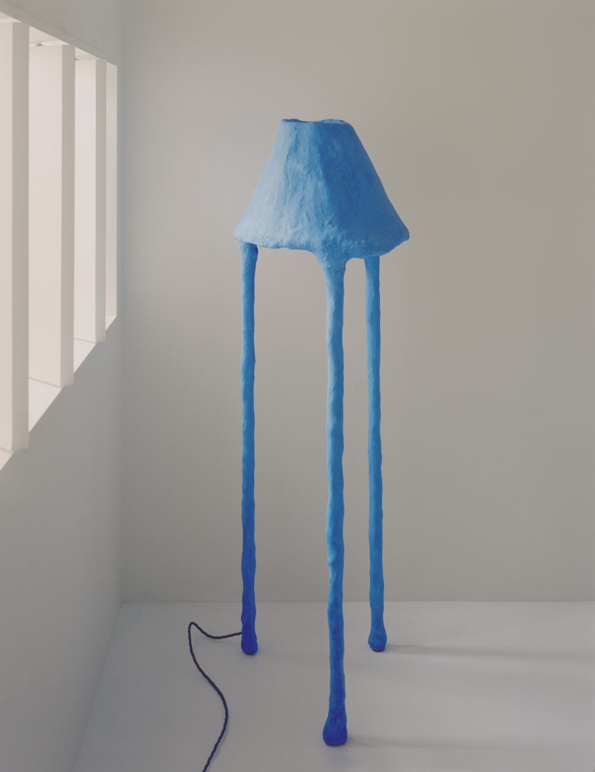 Blue mushroom-like floor lamp against a white backdrop