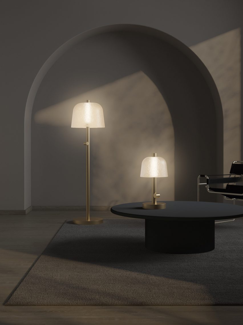 Photo of the Symbioosa floor and table lamps by Lasvit giving off a soft, warm light through textured glass lampshades in a dark room