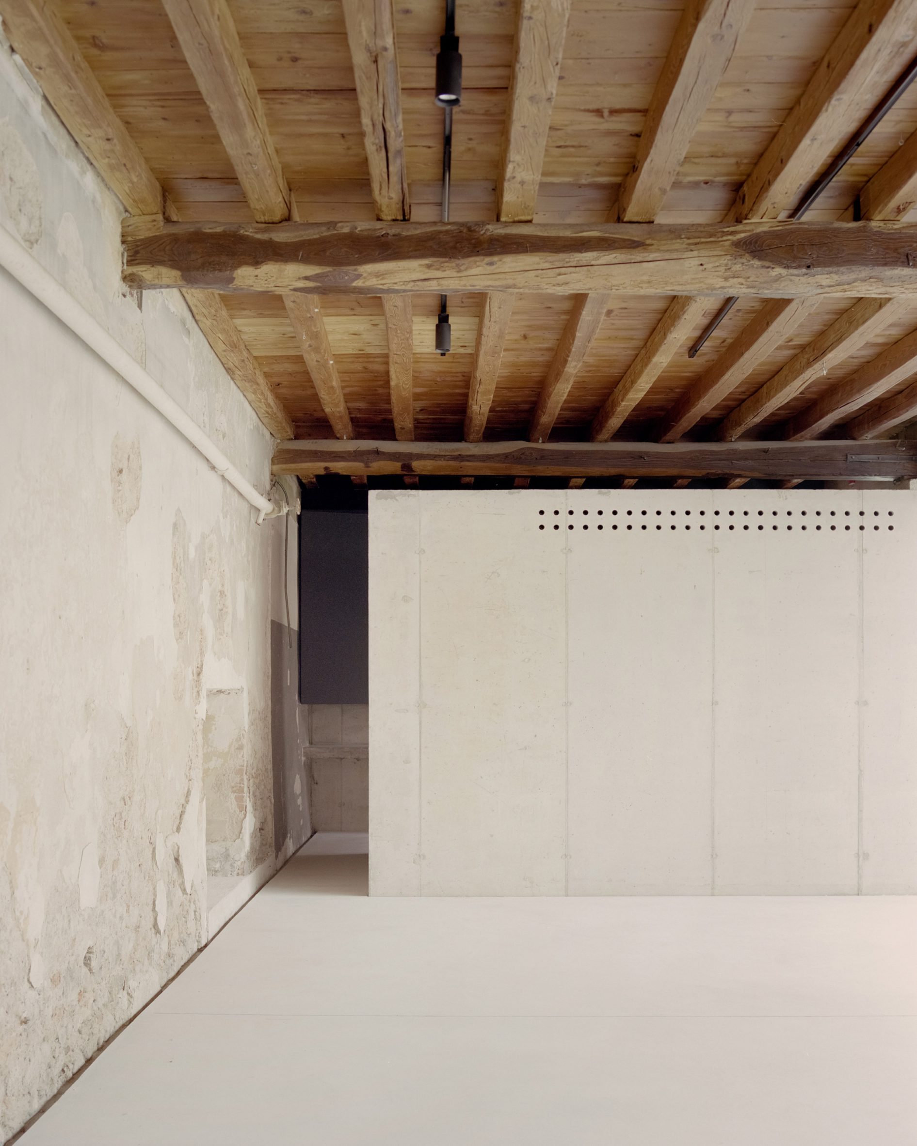 Art gallery with exposed concrete walls and timber ceiling