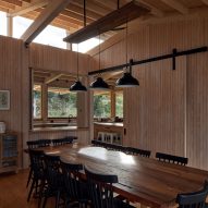 A dining room in a timber structure with a pitched roof and high-level windows