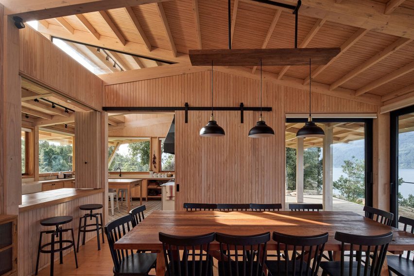 Dining room with timber-clad walls and pitched roof with exposed wood structure
