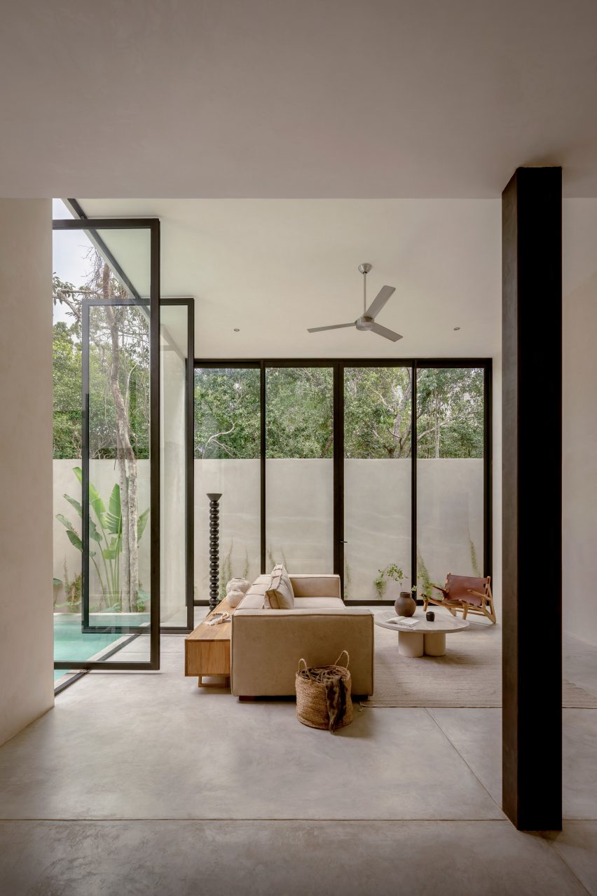 Tall floor-to-ceiling glazing framing the living space in Espacio 18's Tulum concrete holiday home