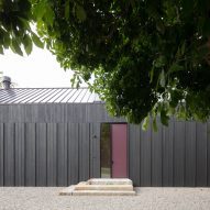 Entrance to a black timber-clad barn-style home