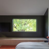 Bedroom with a dark blue accent wall at the New York farmhouse by Worrell Yeung