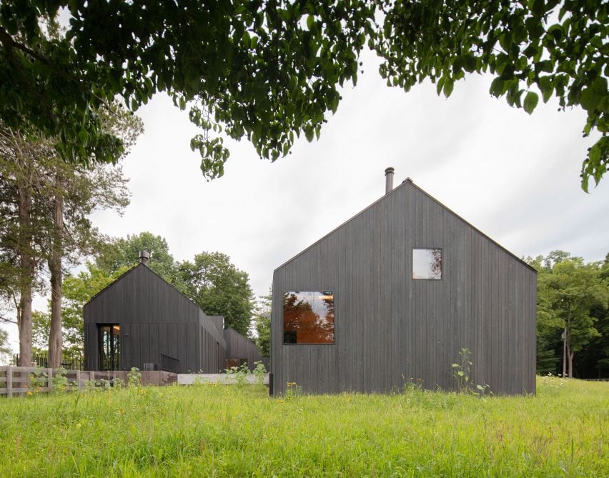 Two black timber barn-style buildings by Worrell Yeung