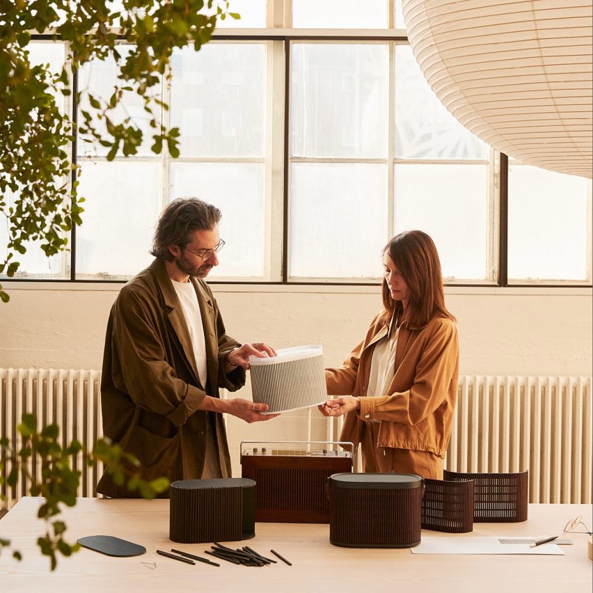 Photo of two people holding a speaker by Bang & Olufsen