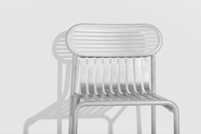 Detalle de silla metálica brillante en sala blanca