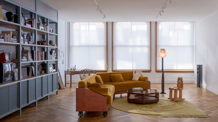 Living room with open-shelf storage and ochre-coloured sofa