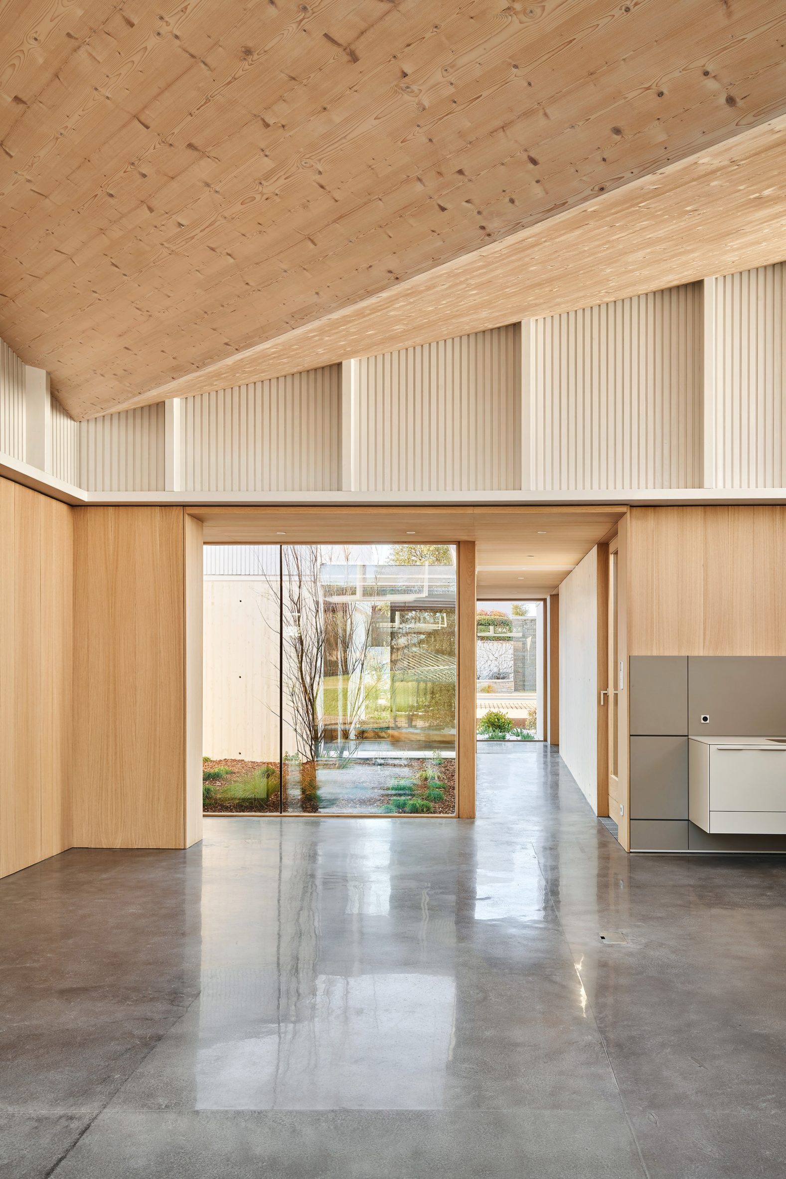 Home interior with a mono-pitched timber roof and concrete floors by Arquitecturia